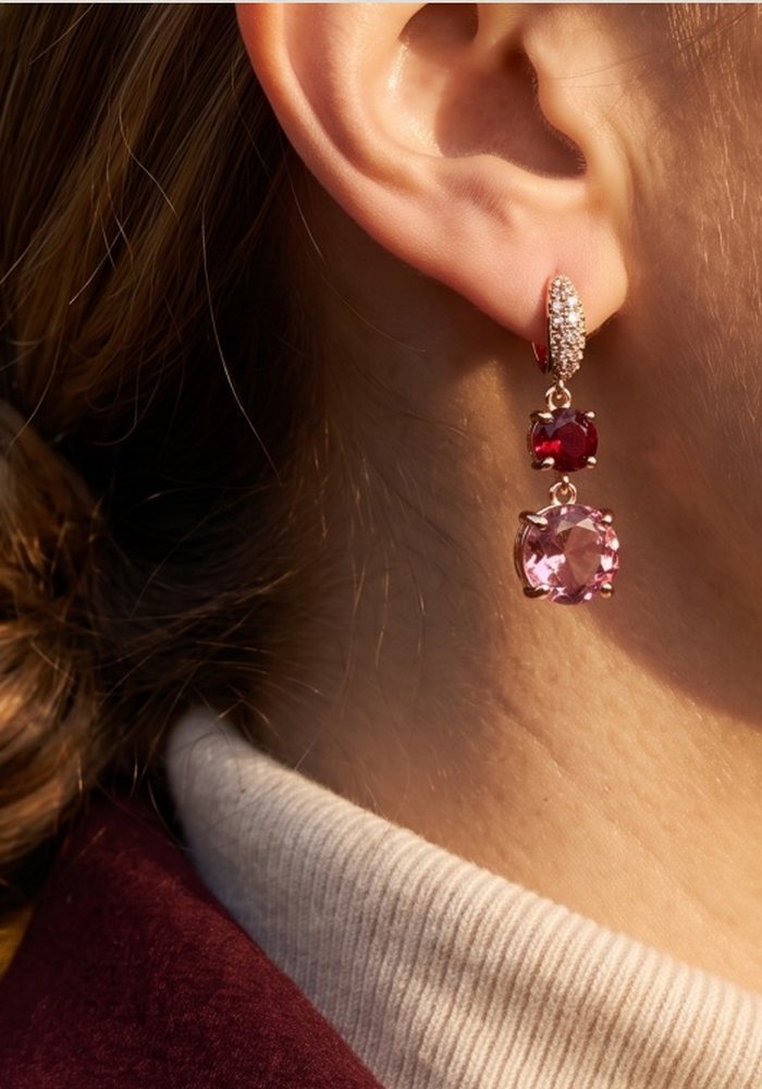 Orecchini pendenti con pietre rosa e rosse indossati