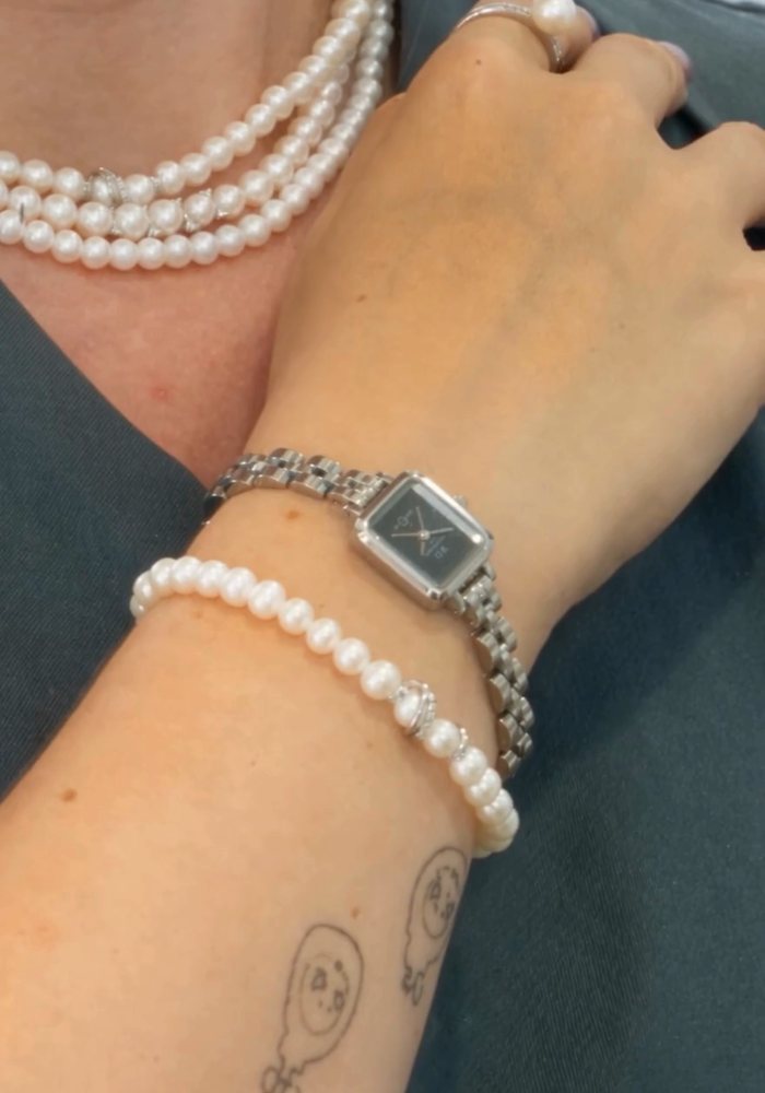Collana di perle, anello con perla e orologio indossati