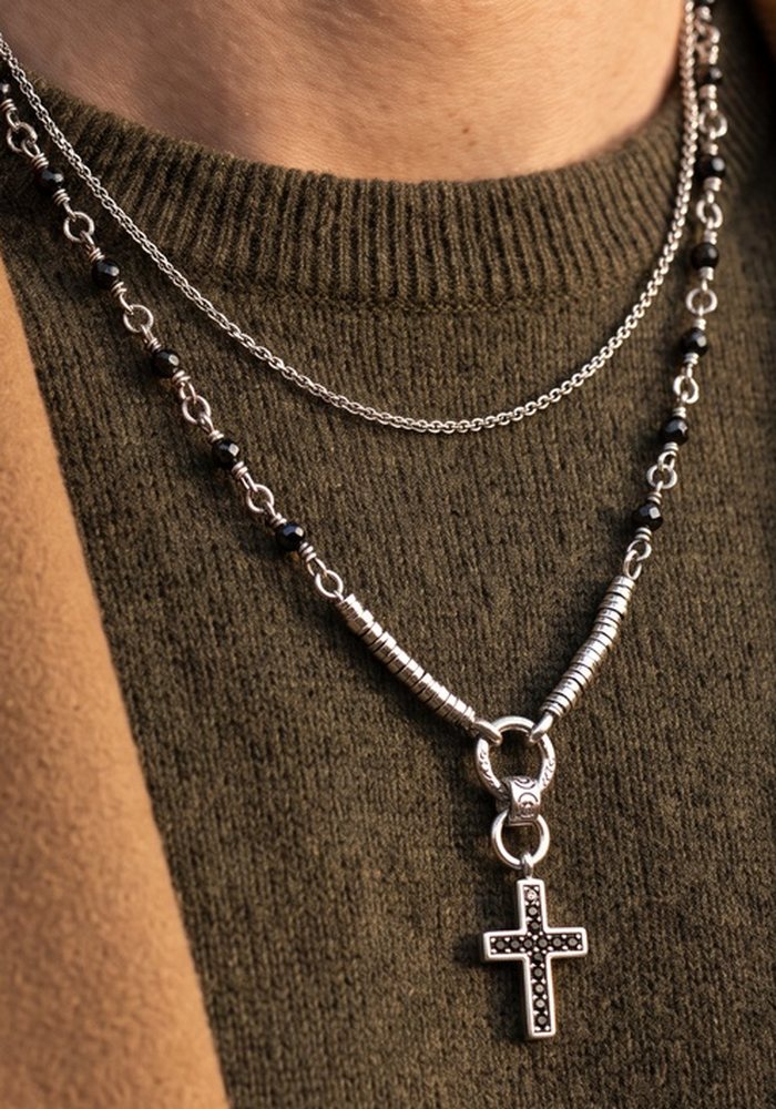 Collana a doppio filo con croce su maglione verde