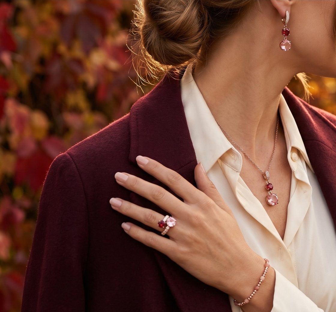 Mano con anello e bracciale su un cappotto bordeaux, in autunno
